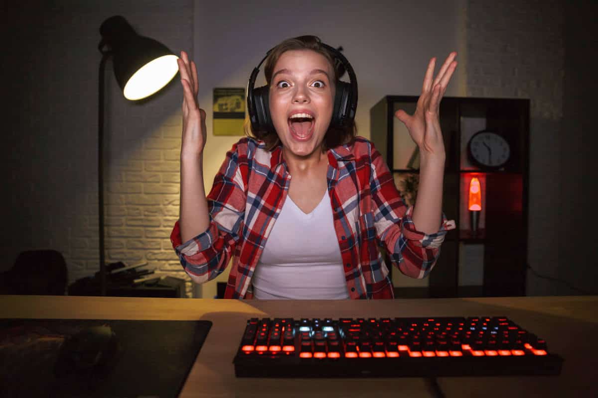 Excited gril gamer sitting table playing | The Ultimate Guide To PC Games
